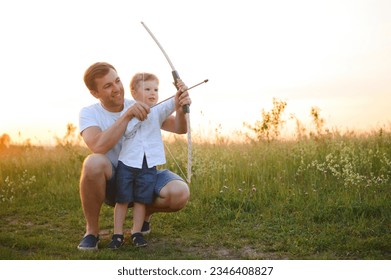 a man and a little boy doing archery. - Powered by Shutterstock