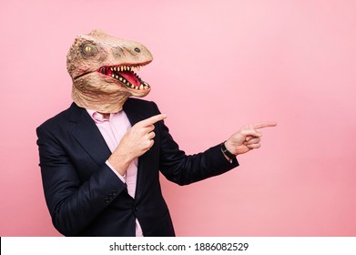 Man with lizard head and pointing fingers to the side.
