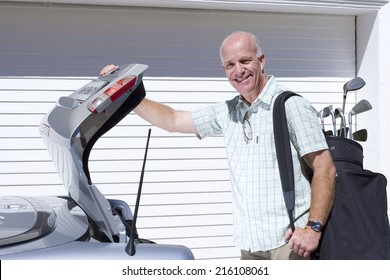 Man Loading Golf Clubs Into Car Trunk