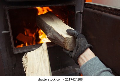 Man loads the firewood in the solid fuel boiler in the boiler room. Solid fuel and heating concept  - Powered by Shutterstock