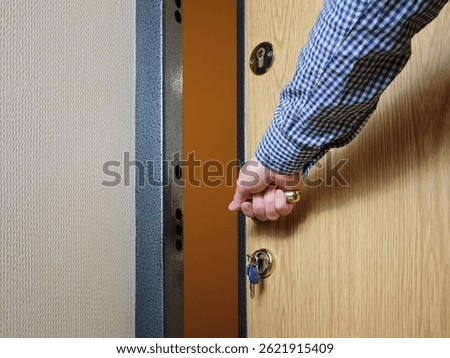 A man locks or opens the front door from the inside when entering his house or apartment. The concept of security and personal boundaries.