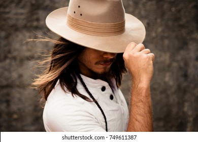 Man with a long hair, hiding his face in hat - Powered by Shutterstock