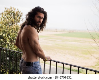 Man With Long Hair And No Upper Cloth On A Roof