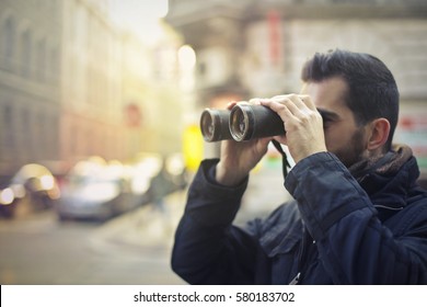 Man Looking Around The City With A Binocular