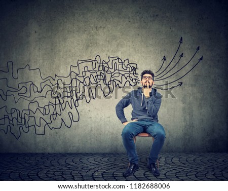 man looking up brainstorming getting his thoughts together planning making conclusions isolated on gray wall background