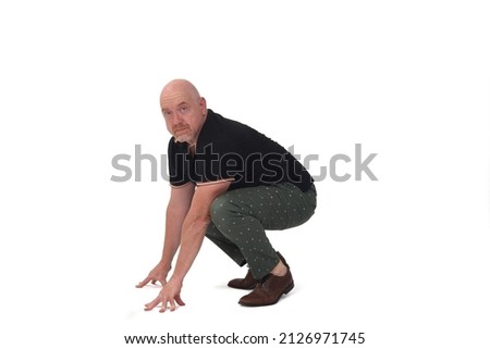 man looking at camera and sitting squatting on white background