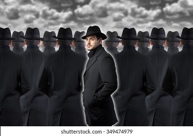 Man looking at camera while standing out from the crowd