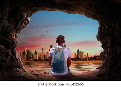 a man looking at the city view of kuwait from a cave 