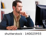 Man looking at a computer screen, thinking about the job at hand