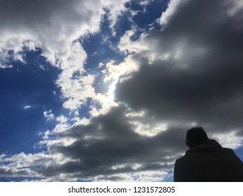 Man looking at dark clouds