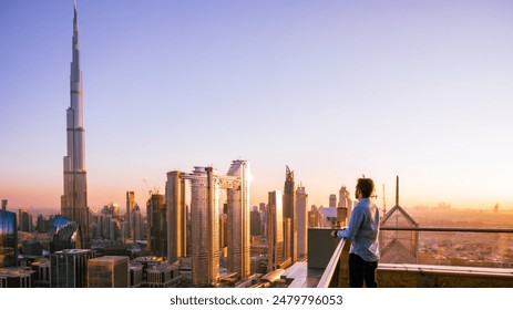 Man looking to Dubai sunset with views to the city centre from a skyscraper