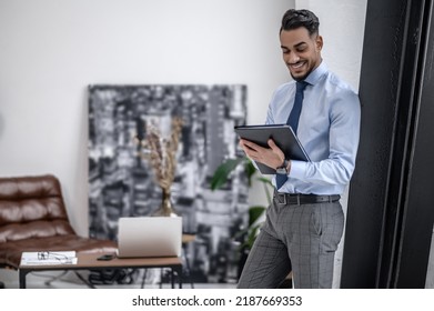 Man looking at folder in hands standing indoors - Shutterstock ID 2187669353
