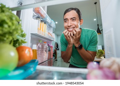 Man Looking For Food Inside The Fridge At His Home