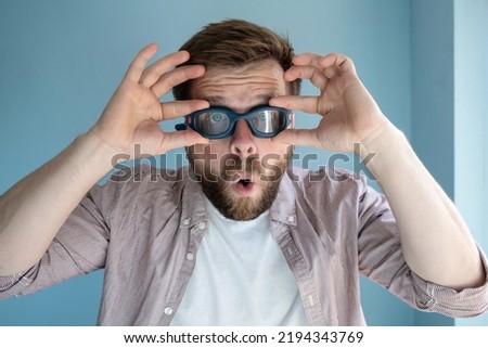 Similar – Man observing something through binoculars