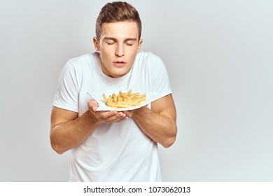 The Man Is Looking At The Fried Potatoes In A Plate                             