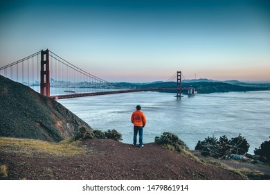 A Man Looking To Golden Gate Bridge At Sunset Pacific Ocean Overlook Orange Jacket People In San Francisco