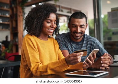 Man looking at his girlfriend shopping online in cafe