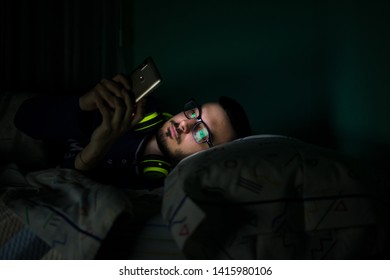 Man Looking His Mobile Phone In The Bed At Night. Lifestyle Concept, Technology.