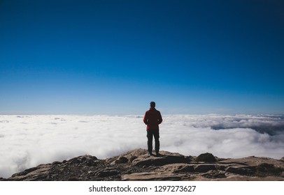 man looking at the horizon above the clouds in the mountain