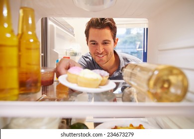 Man Looking Inside Fridge Full Of Unhealthy Food