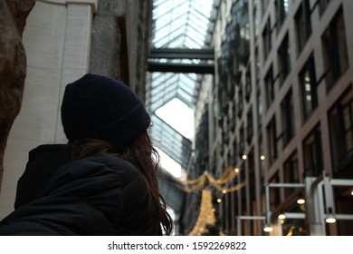 Man looking up into building ceiling.