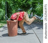 man looking into trash can .search for content for photo