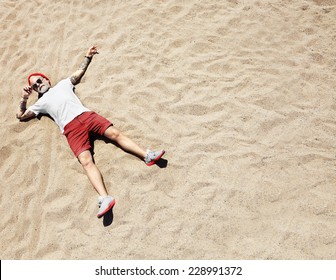 Man, Looking Like A Santa Lying Down On A Beach