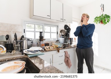 Man Looking At The Messy Kitchen In Then Morning, Full Of Rubbish And Dirty Dishes. Morning Light Apartment