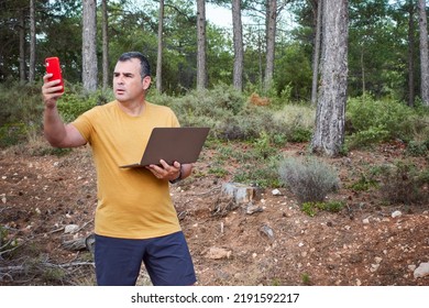 A Man Looking For Mobile Phone Coverage To Share Data And Be Able To Use The Computer In The Field