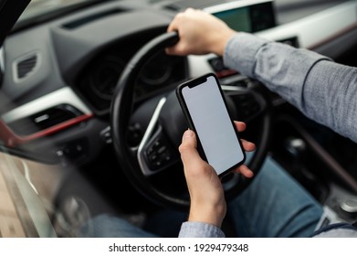 Man Looking At Mobile Phone While Driving A Car