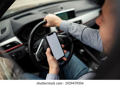 Man Looking At Mobile Phone While Driving A Car