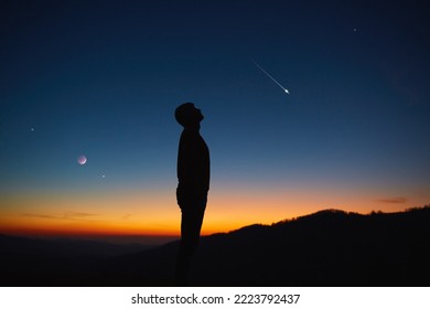 Man looking at the night sky, stars, planets, Moon and shooting stars.