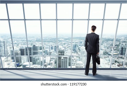 man looking on city through the window