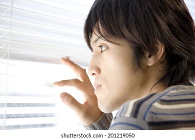 Man looking over a roller blind