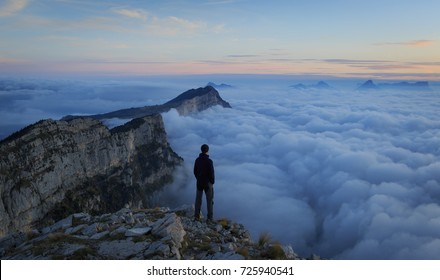 Man looking over a sea of clouds in the Vercors mountains. France.