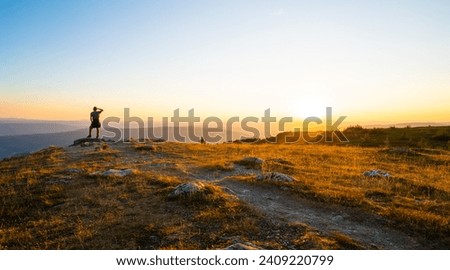 Man looking over the surroundings at a sunset in beautiful hafjelltoppe in Norway, Europe