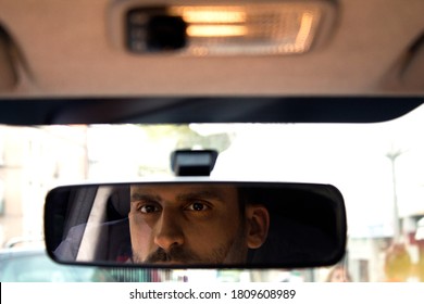 Man Looking In The Rear View Mirror Of The Car