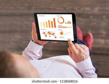 Man Looking At Sales Data On Tablet