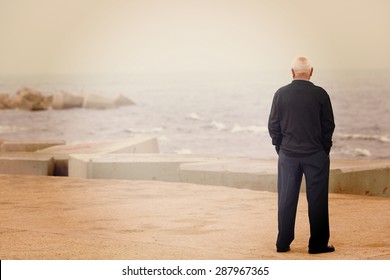 A man looking at the sea on the dock. Image has a vintage effect. - Powered by Shutterstock