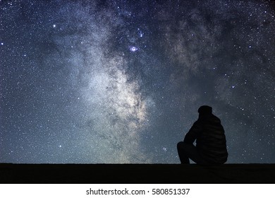 Man looking at the stars. Alone man looking at starry sky. Night sky.