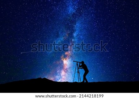 Man looking at the stars through a telescope