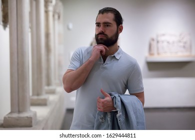 Man looking at stone architectural elements in historical museum hall 