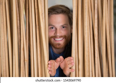 man looking through a bamboo curtain