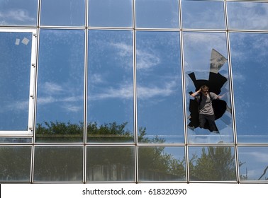 A man looking through a broken window