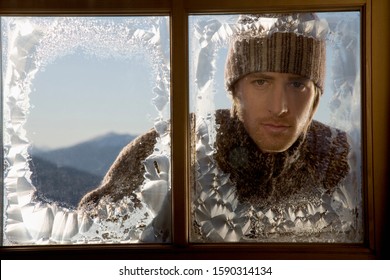 Man Looking Through Frosty Window