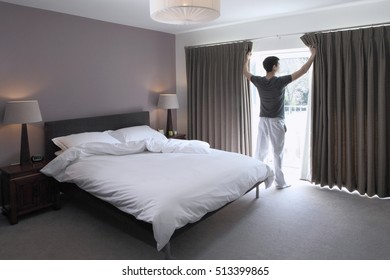 Man Looking Through Glass Door Of Bedroom