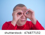 man looking through hands, making binoculars