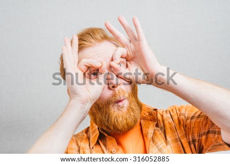 man  looking through hands, making binoculars