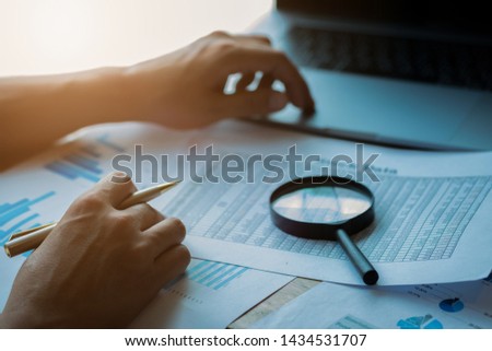 man looking through a magnifying glass to documents. Business assessment and audit. Magnifying glass on a financial report. Close-up Of Businessperson Checking Bills With Magnifying Glass.