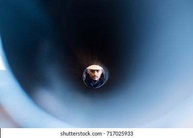 Man Looking Through A Pipe